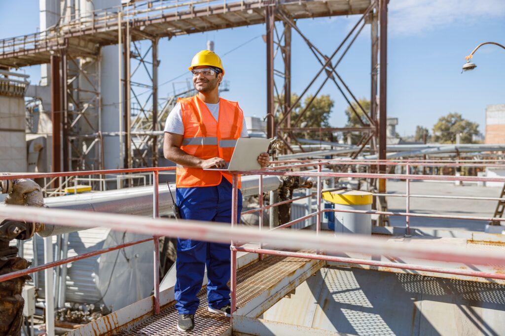 Worker with safety equipment working at heavy industry plant