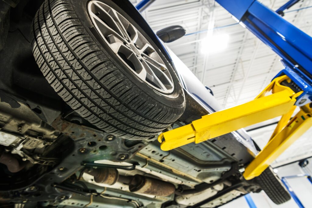 Broken Car on an Automotive Lift Inside Auto Service Center